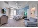 Cozy main bedroom with a tray ceiling, accent wall, and ensuite bathroom at 5301 Amersham Ln, St Cloud, FL 34771