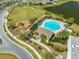 Aerial view of a community pool, pool house, and playground near neighborhood at 5301 Amersham Ln, St Cloud, FL 34771