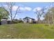 Exterior of home with backyard featuring a grassy area, shed, and wood fence at 5990 Hibiscus Rd, Orlando, FL 32807