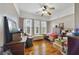 Bedroom with hardwood floors, ceiling fan, and plenty of natural light from three large windows at 5990 Hibiscus Rd, Orlando, FL 32807