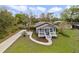 Aerial view of a gray home with a quaint front porch, green lawn and a long driveway at 5990 Hibiscus Rd, Orlando, FL 32807