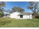 Exterior view of the backyard featuring a lush green lawn and sliding glass doors at 6222 Fox Hunt Trl, Orlando, FL 32808