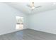 Bright bedroom featuring grey wood-look floors, white walls, a ceiling fan, and a large window at 6222 Fox Hunt Trl, Orlando, FL 32808