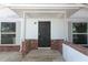 A close-up of the front porch with brick accent, modern windows, and a black security door at 6222 Fox Hunt Trl, Orlando, FL 32808