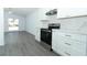 Modern kitchen with stainless steel range oven and white cabinets and a view to a combined dining room area at 6222 Fox Hunt Trl, Orlando, FL 32808