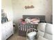 Cozy bedroom with a crib, changing table, and accent decorations at 7018 Stockholm Way, Orlando, FL 32822