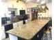 Well-lit kitchen featuring granite counters, white cabinets and black appliances at 7018 Stockholm Way, Orlando, FL 32822