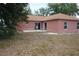 Cozy single-story home featuring a brown roof and backyard area with two sliding glass doors at 721 Waxwing Ct, Kissimmee, FL 34759