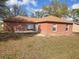 Backyard of a single-story home featuring a patio and mature shade trees at 721 Waxwing Ct, Kissimmee, FL 34759