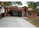 Exterior view of a single-story home with an open garage filled with boxes and household items at 721 Waxwing Ct, Kissimmee, FL 34759