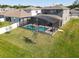 Aerial view of a backyard featuring a sparkling blue pool enclosed by a screened enclosure and green lawn at 793 Hyperion Dr, Debary, FL 32713