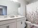 Bright bathroom featuring a double vanity with modern faucets and a shower-tub with decorative curtain at 793 Hyperion Dr, Debary, FL 32713