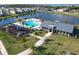 Aerial view of a community pool and recreation area with a playground, clubhouse, and lush landscaping by the lake at 793 Hyperion Dr, Debary, FL 32713