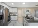 Well lit kitchen features modern stainless steel appliances, with an island and quartz countertop at 803 Marquis Ct, Kissimmee, FL 34759