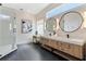 Contemporary bathroom featuring a double vanity with stylish round mirrors, a makeup table, and sleek fixtures at 806 Roswell Cv, Lake Mary, FL 32746