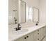 Modern bathroom with double sinks, framed mirrors, and a combination of white and black fixtures at 806 Roswell Cv, Lake Mary, FL 32746