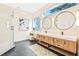 Modern bathroom featuring a double vanity with round mirrors, a makeup table, and a glass-enclosed shower at 806 Roswell Cv, Lake Mary, FL 32746