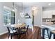 Bright breakfast nook features a wooden table, black chairs, wood floors, and pendant lighting at 806 Roswell Cv, Lake Mary, FL 32746