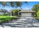 Single-story home with a two-car garage, a well-manicured lawn, and beautiful mature landscaping at 806 Roswell Cv, Lake Mary, FL 32746