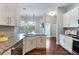 This kitchen showcases white cabinets, granite countertops, stainless steel appliances, and wood flooring at 806 Roswell Cv, Lake Mary, FL 32746