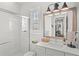 Bright bathroom featuring tiled shower, white vanity, and decorative mirror at 936 Allendale Ln, Winter Garden, FL 34787