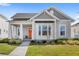 Charming single-Gathering home featuring a well-manicured lawn and an inviting orange front door at 936 Allendale Ln, Winter Garden, FL 34787