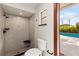 Modern bathroom features a tiled walk-in shower with a corner seat and a view of the pool area at 9360 Sonia St, Orlando, FL 32825