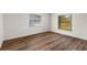 Bright and airy empty room featuring wood floors and natural light from the windows at 9360 Sonia St, Orlando, FL 32825