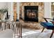 Close-up of the stone fireplace with cozy fire burning, creating a warm ambiance in the living room at 9360 Sonia St, Orlando, FL 32825