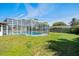 Screened-in pool surrounded by green yard at 1109 Denton Rd, Winter Park, FL 32792