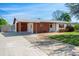 Single-story home with covered parking, red brick accents and mature landscaping at 1109 Denton Rd, Winter Park, FL 32792