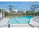 In-ground pool enclosed with screen, surrounded by mature landscaping under bright blue sky at 1109 Denton Rd, Winter Park, FL 32792