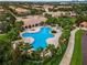 Beautiful aerial view of uniquely shaped outdoor pool with surrounding trees and scenic views of nearby buildings at 12016 Lorenza Ln, Orlando, FL 32827