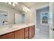 Bathroom featuring a double vanity, a large mirror and a separate toilet room at 12016 Lorenza Ln, Orlando, FL 32827