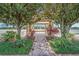 Charming brick pathway leading to an elegant gazebo framed by mature trees and manicured landscaping at 12016 Lorenza Ln, Orlando, FL 32827