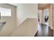 A hallway featuring wood floors and neutral walls leading to a room with a desk at 12016 Lorenza Ln, Orlando, FL 32827