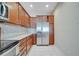 Kitchen with stainless steel refrigerator, granite countertops, and wooden cabinetry at 12016 Lorenza Ln, Orlando, FL 32827