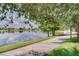 Scenic view of a paved sidewalk running alongside a tranquil lake and lush greenery at 12016 Lorenza Ln, Orlando, FL 32827