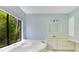 Bathroom with vanity and soaking tub by a large window with a lush green view at 1213 Richmond Rd, Winter Park, FL 32789