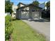 Large two-car garage featuring an extended driveway and lush landscaping at 1213 Richmond Rd, Winter Park, FL 32789