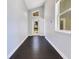 Hallway with dark wood floors and natural light coming through a door with a transom window at 1213 Richmond Rd, Winter Park, FL 32789