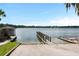 Beautiful lake view with boat ramp, pier, and a small boathouse, trees visible in the distance at 1213 Richmond Rd, Winter Park, FL 32789