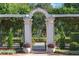 Scenic park view through stone archway, featuring manicured greenery, benches, and beautiful landscaping at 1213 Richmond Rd, Winter Park, FL 32789