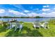 Scenic waterfront view with four white adirondack chairs on the grass next to a small wooden dock at 1213 Richmond Rd, Winter Park, FL 32789