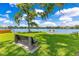 Scenic waterfront view with a bench on the grass underneath a shade tree, and a small wooden dock at 1213 Richmond Rd, Winter Park, FL 32789