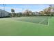 Green tennis court surrounded by mature trees and building exteriors at 1317 S Pine Ridge Cir # 1317, Sanford, FL 32773