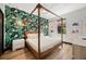 Bright bedroom featuring a four-poster bed, tropical wallpaper, and light hardwood floors at 1412 Moon Valley Dr, Davenport, FL 33896