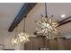 A close up shows the kitchen's starburst pendant lights and dark wood beams at 1412 Moon Valley Dr, Davenport, FL 33896