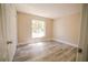 Bright bedroom features modern gray wood flooring and a window that brings in natural light at 1442 S Hawthorne Ave, Apopka, FL 32703