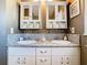 Bathroom featuring double sinks, granite countertops, white cabinetry, and beach themed decorations at 1525 Oakwood Ct, Apopka, FL 32703